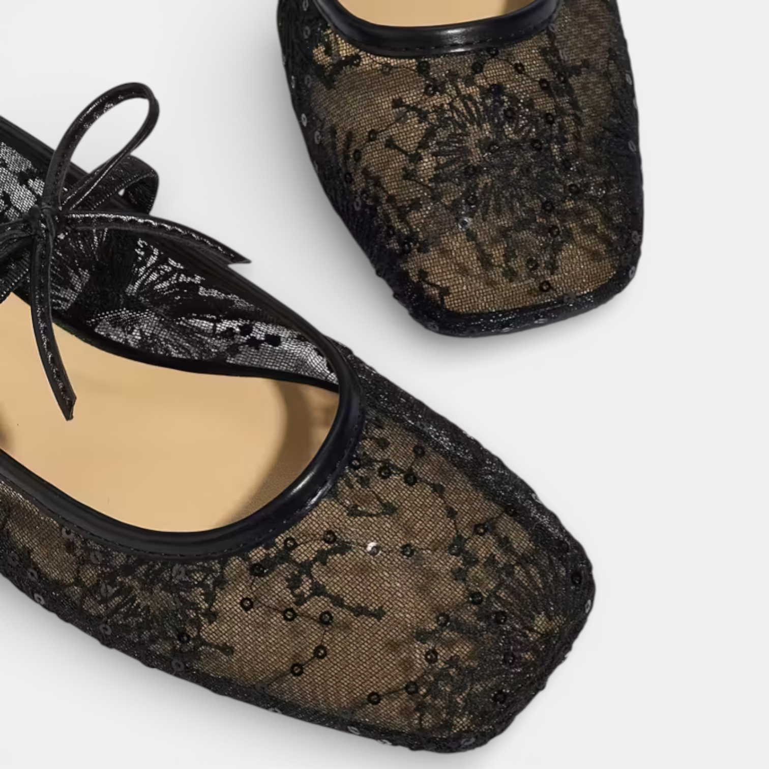 Black lace shoes with sheer design on a white background
