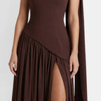 Close-up of a dark brown maxi dress, highlighting the fitted bodice, pleated skirt, and thigh-high slit.
