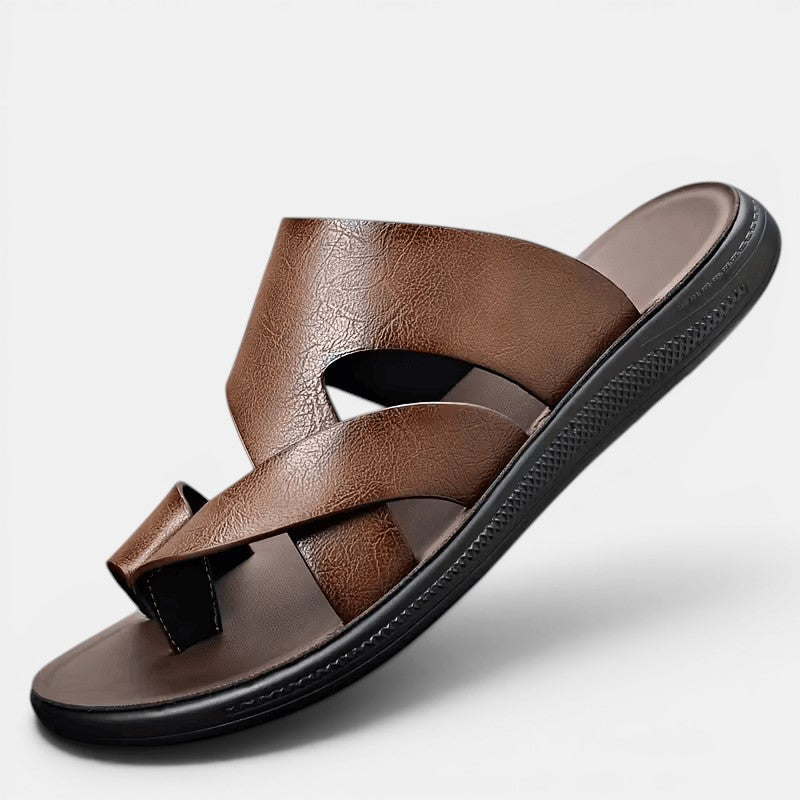 Brown sandal with criss-cross straps on a light gray background