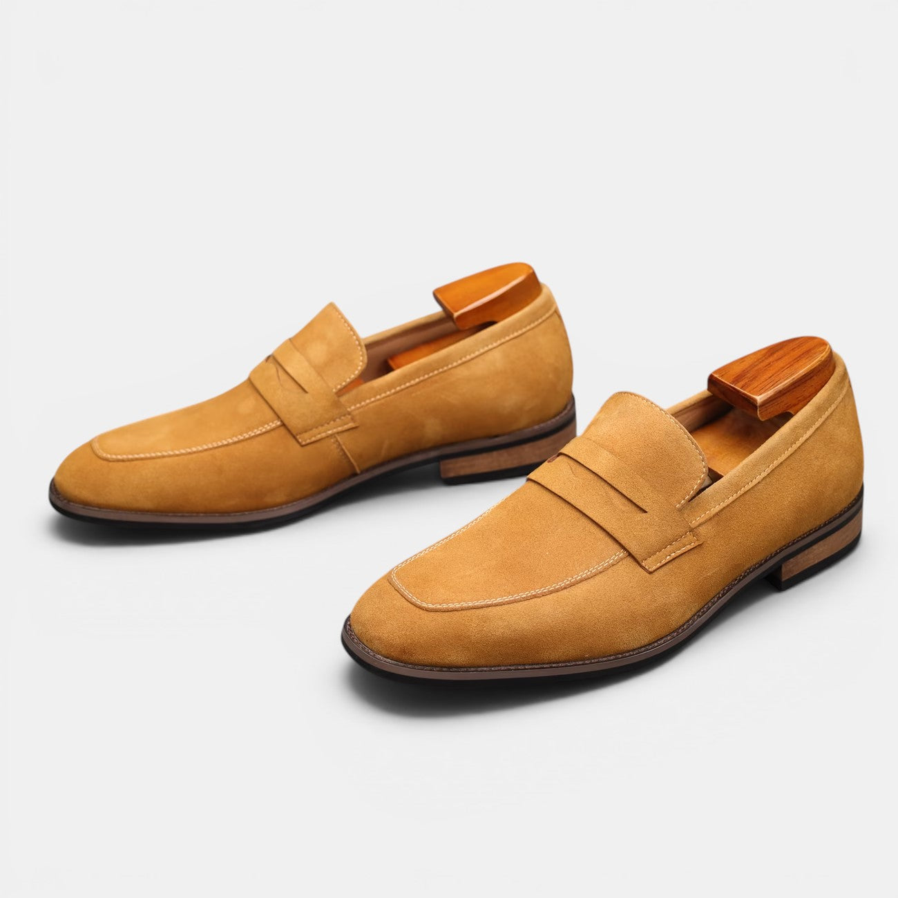 Pair of tan loafers on a light gray background