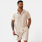 Man wearing a beige linen shirt and shorts set on a white background