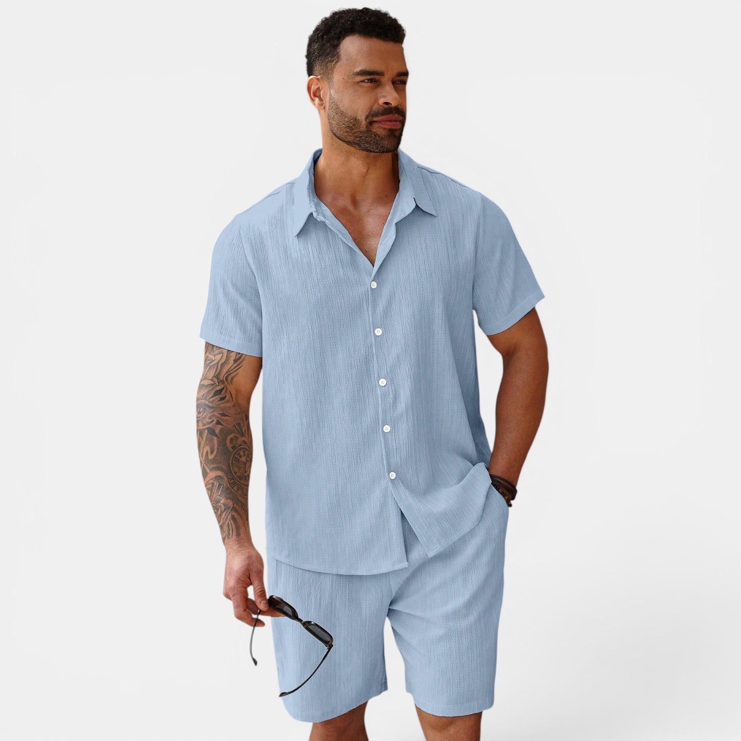 Man wearing a light blue striped shirt and shorts set on a white background