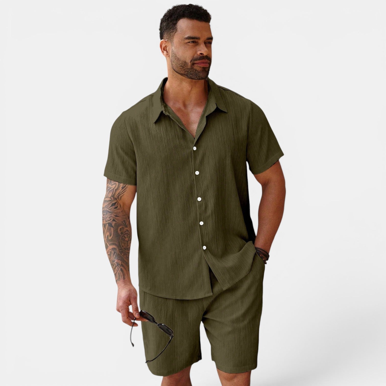 Man wearing an olive green shirt and shorts set on a white background