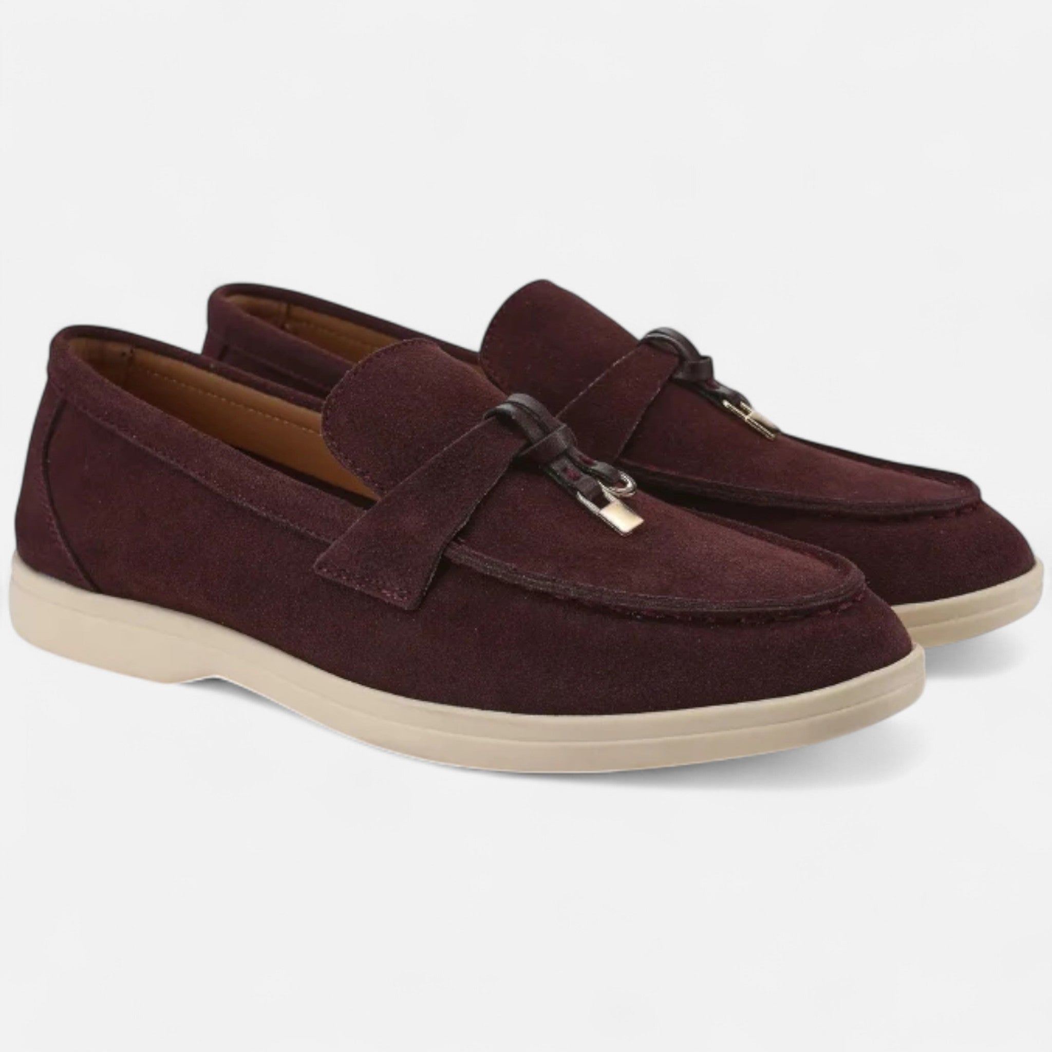 Pair of maroon loafers with beige soles on a white background