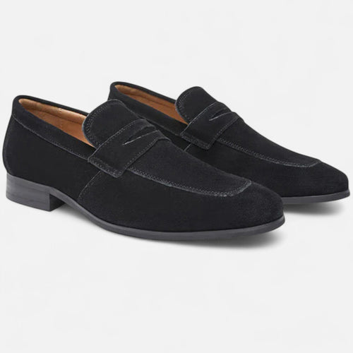 Pair of black suede loafers on a light gray background