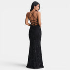 Black lace evening gown with criss-cross back design on a white background