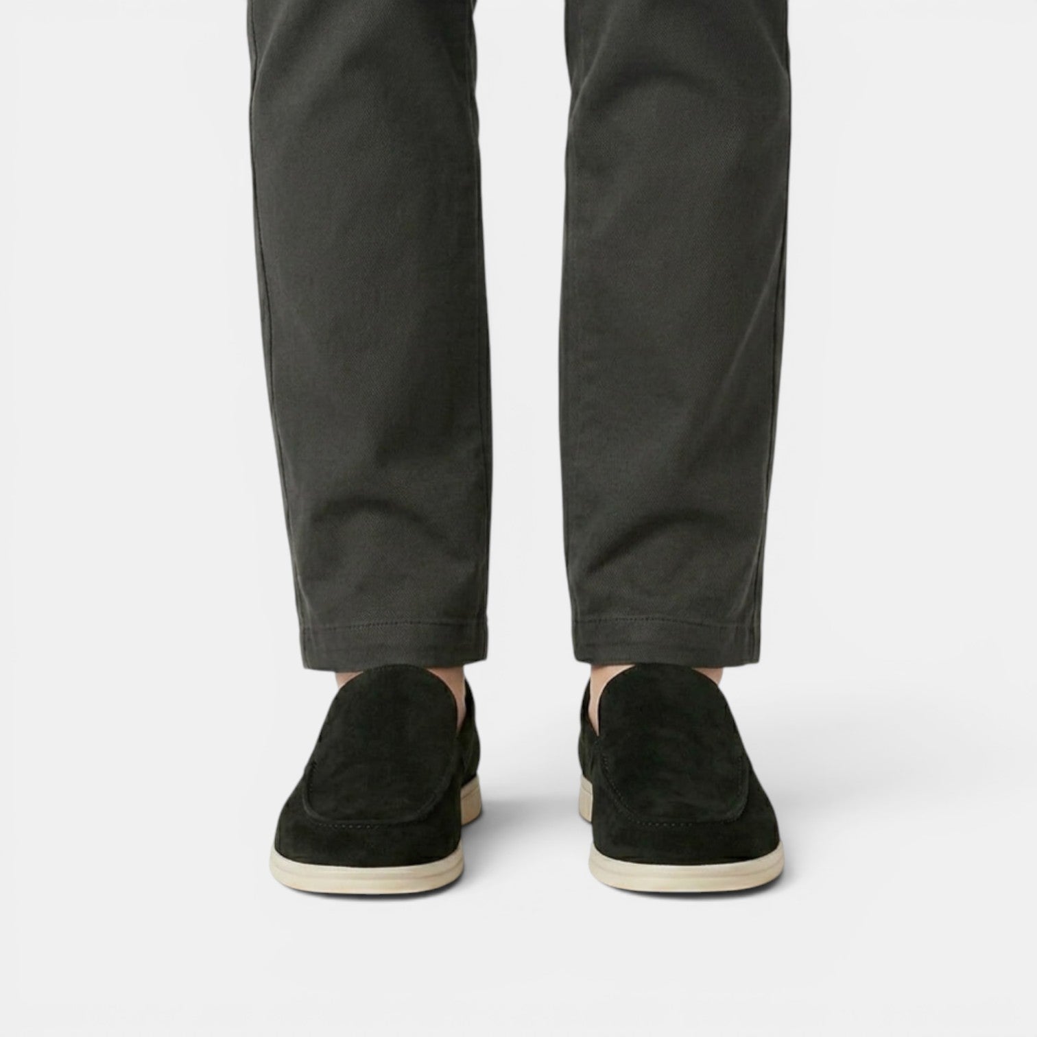 Person wearing black pants and black shoes on a white background