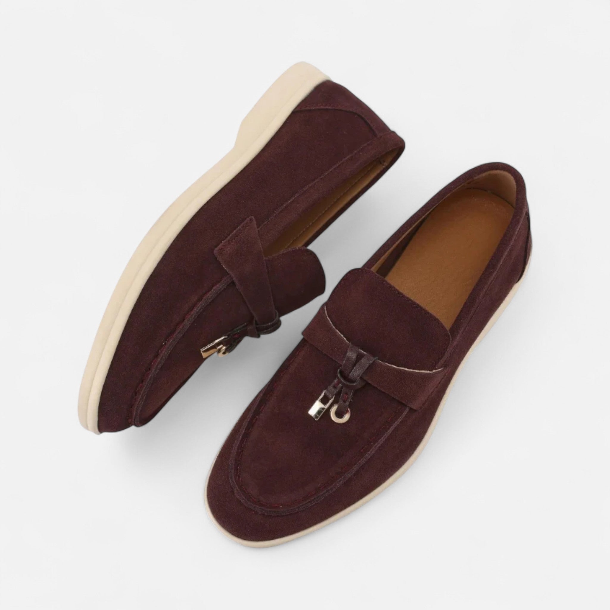 Pair of brown loafers with a tassel on a white background