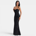 Woman wearing a black lace evening gown on a white background
