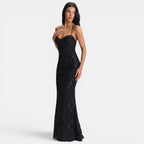 Woman wearing a black lace evening gown on a white background