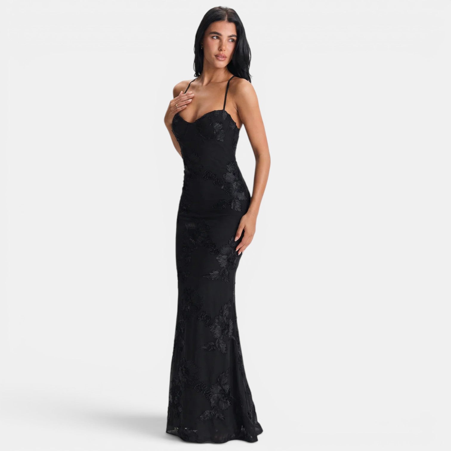 Woman wearing a black lace evening gown on a white background