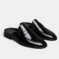 Black patent leather loafers on a light gray background