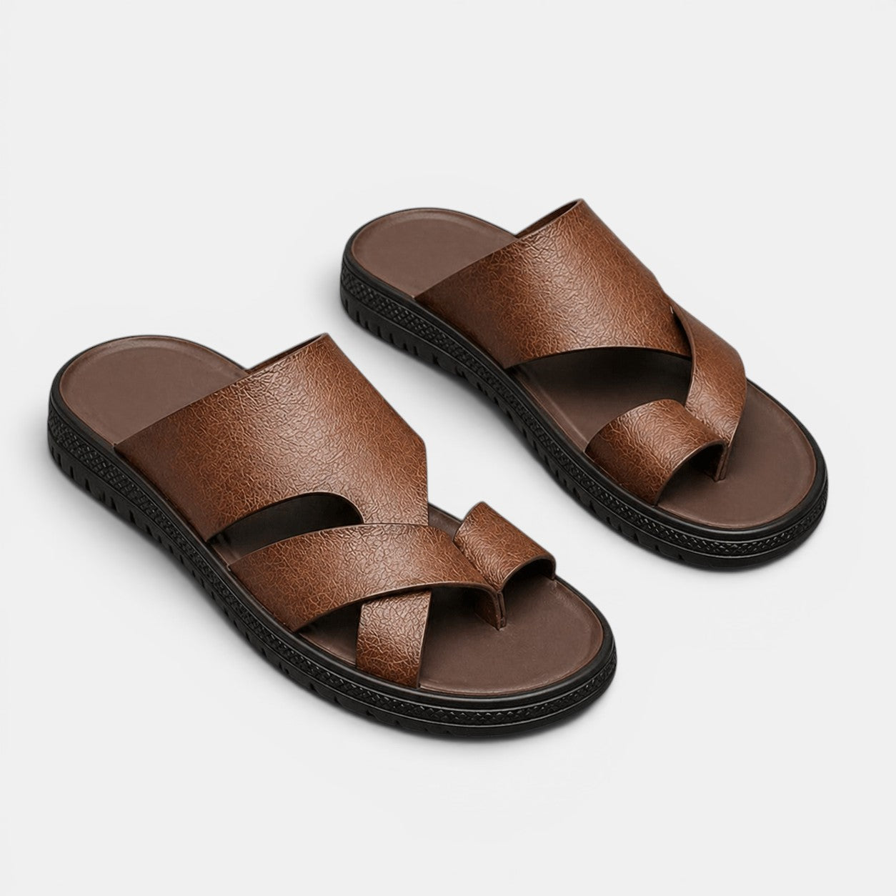 Brown sandals with black soles on a light gray background