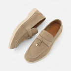 Pair of tan loafers on a white background