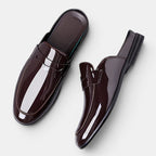 Pair of glossy brown loafers on a white background