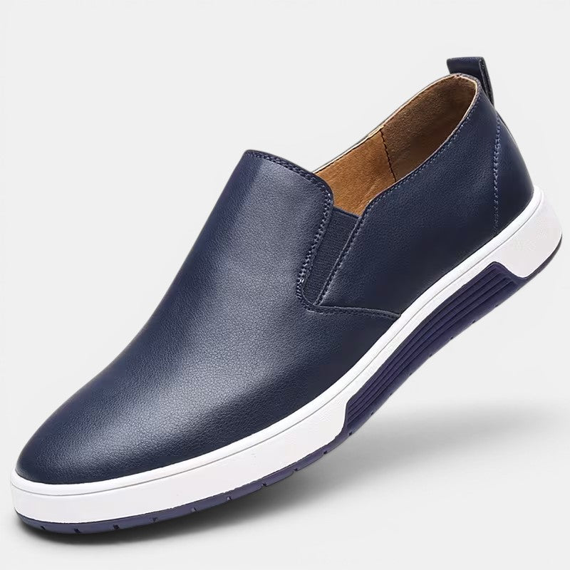 Blue slip-on shoe with white sole on a light gray background