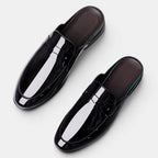 Pair of black glossy loafers on a white background