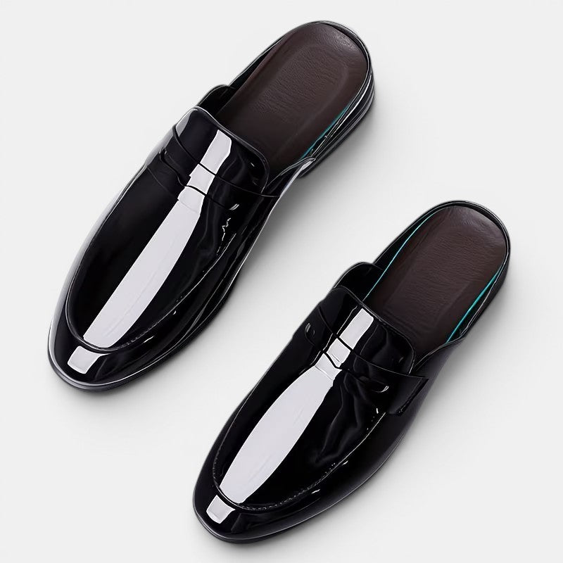 Pair of black glossy loafers on a white background