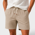 Beige shorts with a drawstring worn by a person on a white background