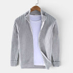 Gray ribbed sweater on a hanger against a white background