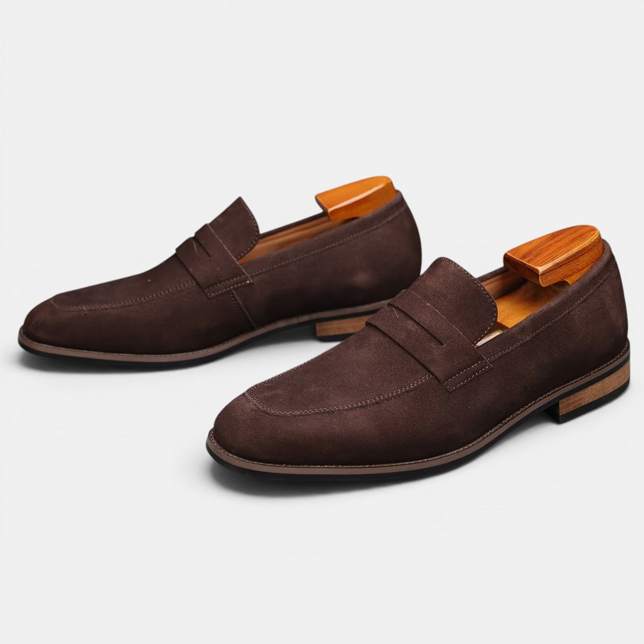 Pair of brown loafers with wooden soles on a white background