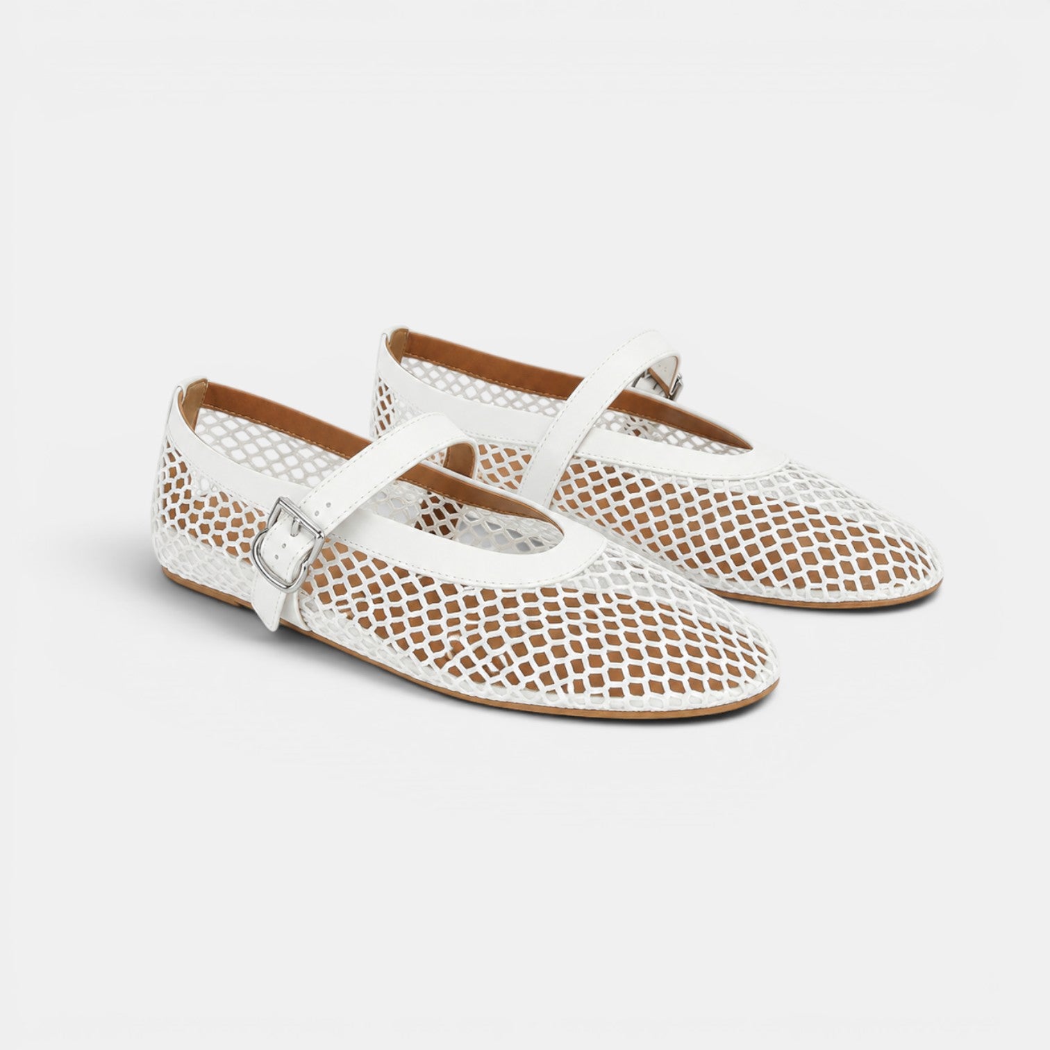 White perforated flat shoes with a strap on a light gray background