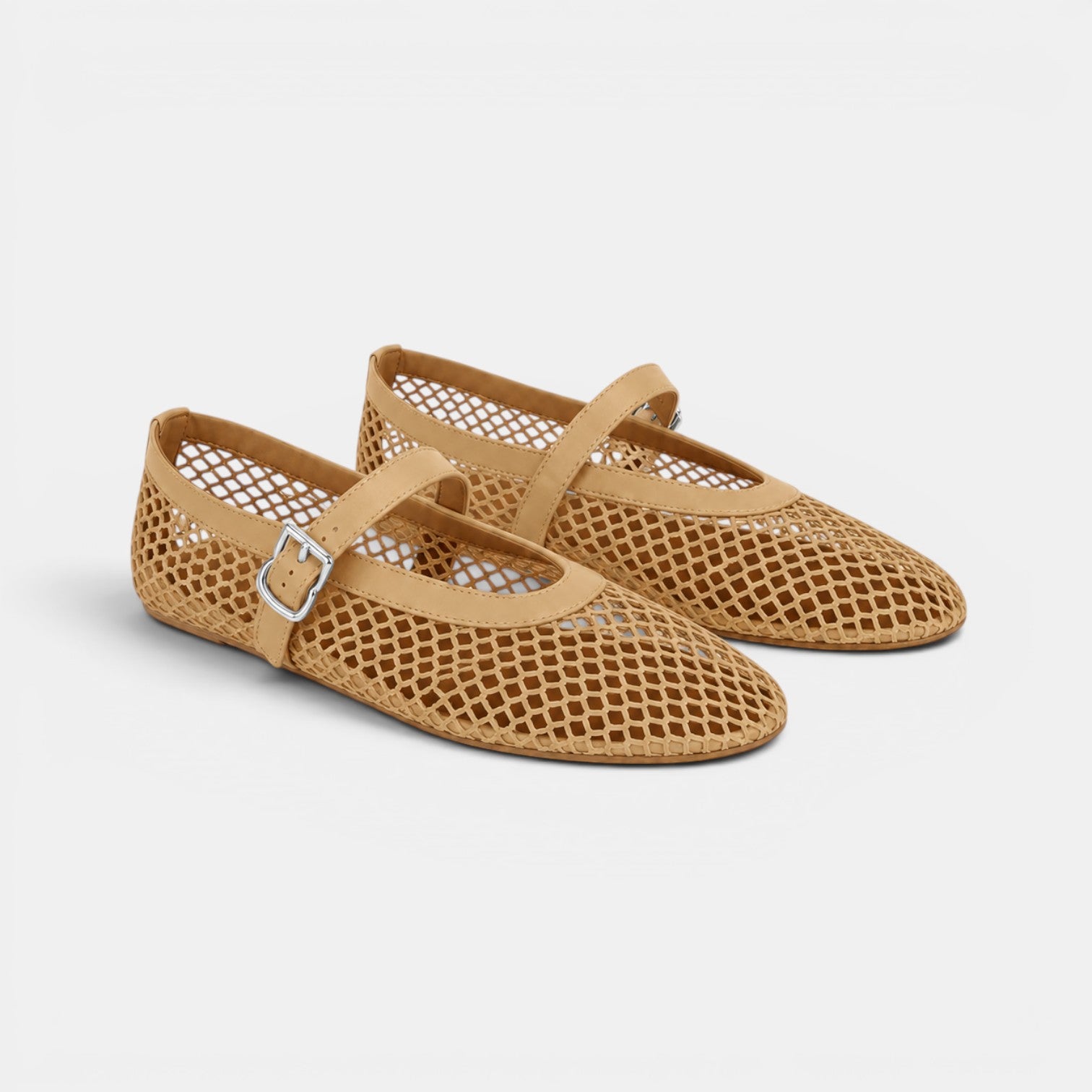 Pair of tan mesh shoes with a strap on a light gray background