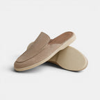 Pair of beige slippers on a light gray background