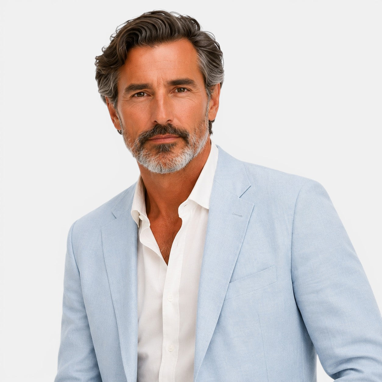 Man wearing a light blue blazer over a white shirt on a plain background