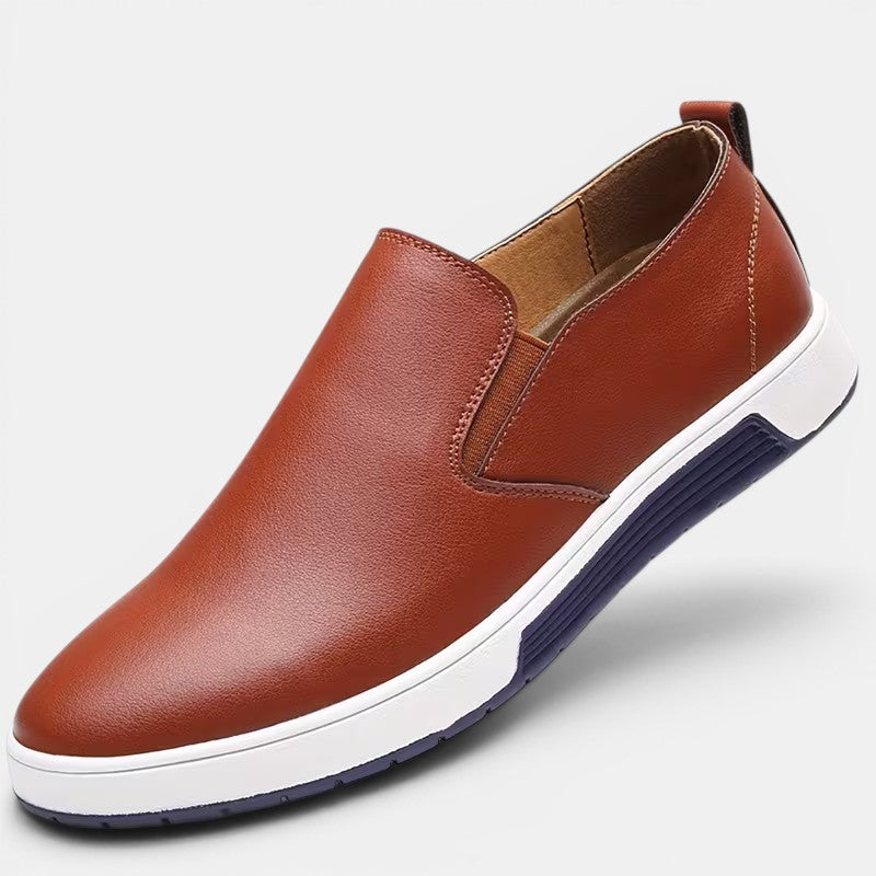 Brown slip-on shoe with white sole on a light gray background