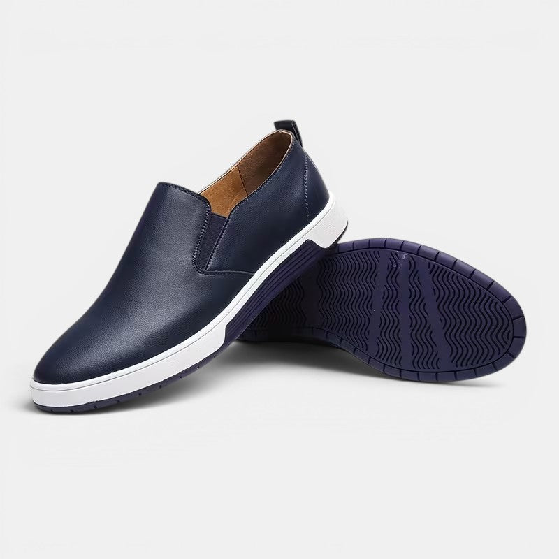 Navy slip-on shoes with white soles on a light gray background