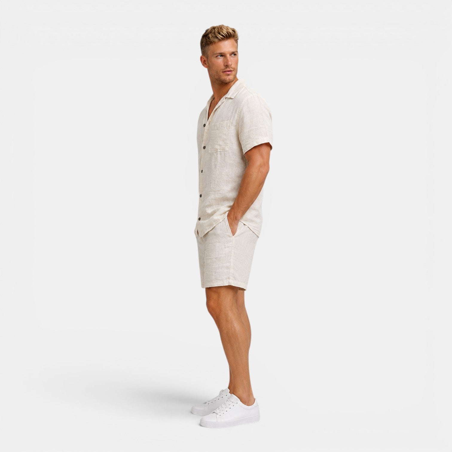 Man wearing a beige linen shirt and shorts set on a white background