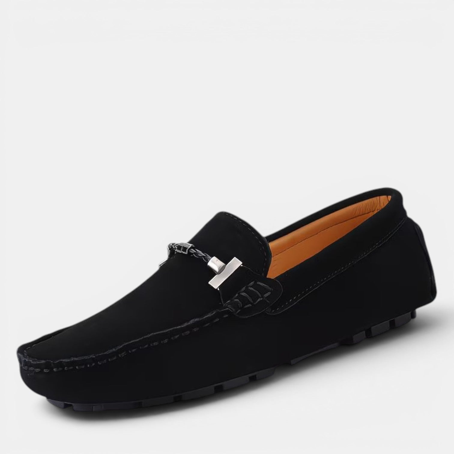Black loafer shoe with a silver buckle on a light gray background