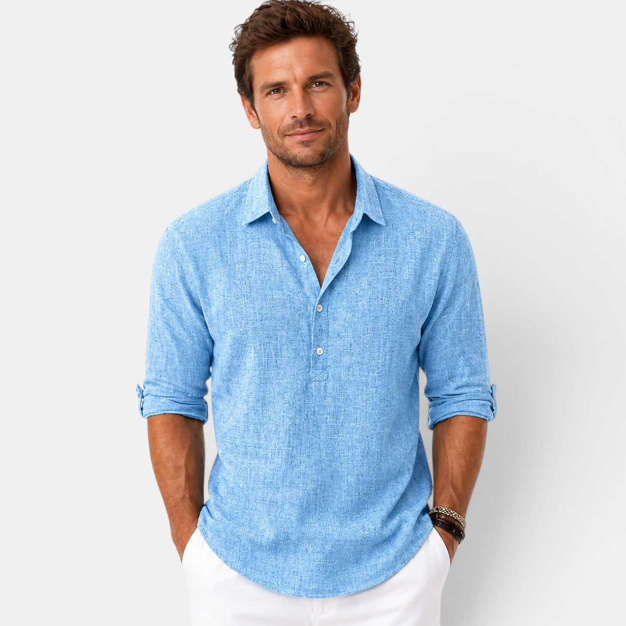 Man wearing a light blue shirt with rolled-up sleeves against a white background