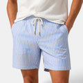 Blue and white striped shorts worn by a person on a plain background
