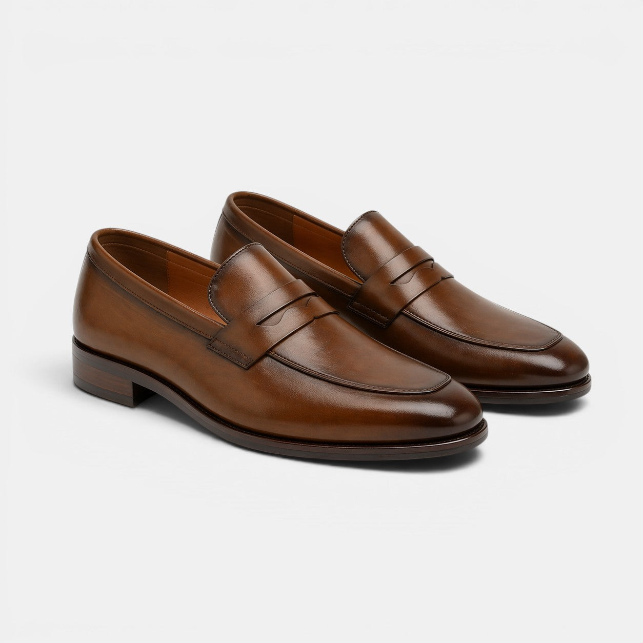 Pair of brown leather loafers on a light gray background