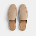 Pair of beige slippers on a light gray background