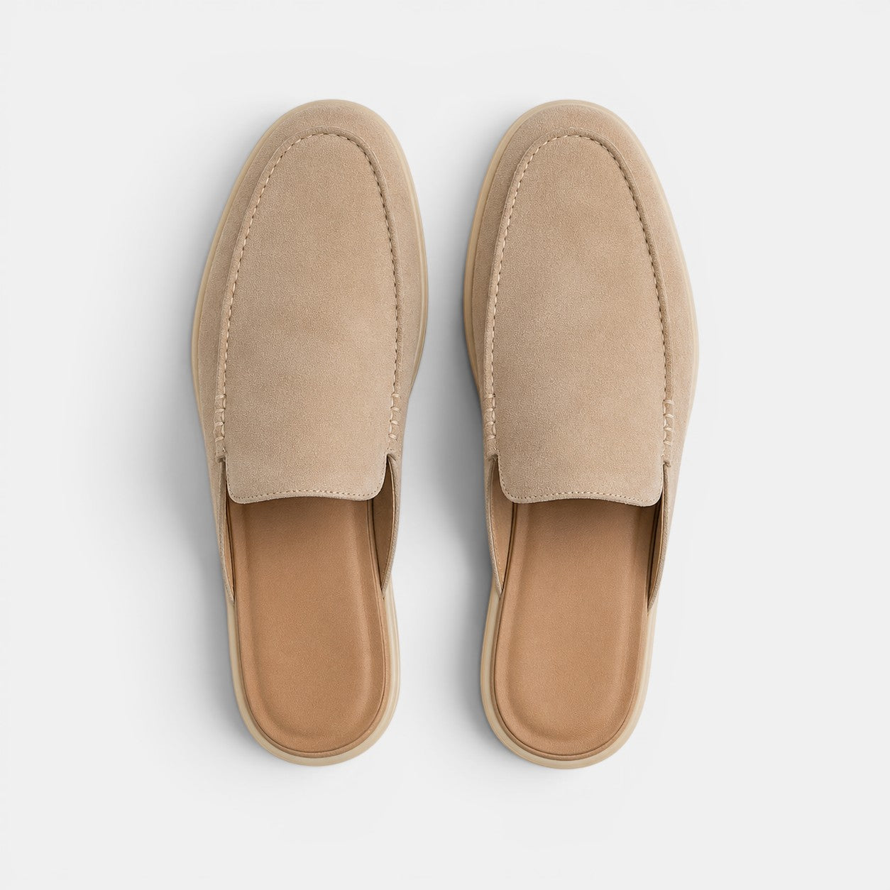 Pair of beige slippers on a light gray background