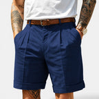Person wearing navy shorts with a white background