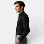 Man wearing a black shirt and gray pants against a white background