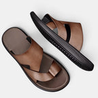 Brown sandals with black soles on a light gray background