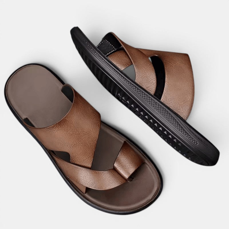 Brown sandals with black soles on a light gray background