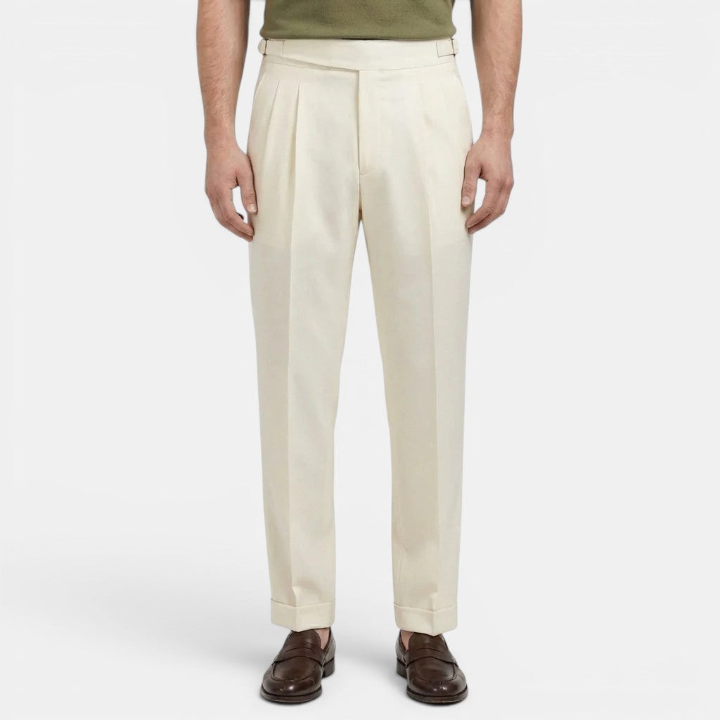 Person wearing beige dress pants on a white background