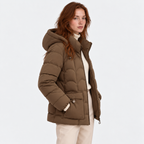Side view of a woman wearing a taupe brown hooded puffer jacket with quilted panels