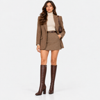 Woman wearing dark brown knee-high boots with a brown skirt and matching jacket