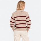 Back view of a woman wearing a beige striped knit sweater with burgundy horizontal stripes