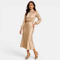 Woman wearing a gold satin dress on a white background