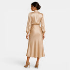 Woman wearing a gold satin dress on a white background