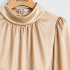 Beige blouse on a hanger with 'Belcien' branding.