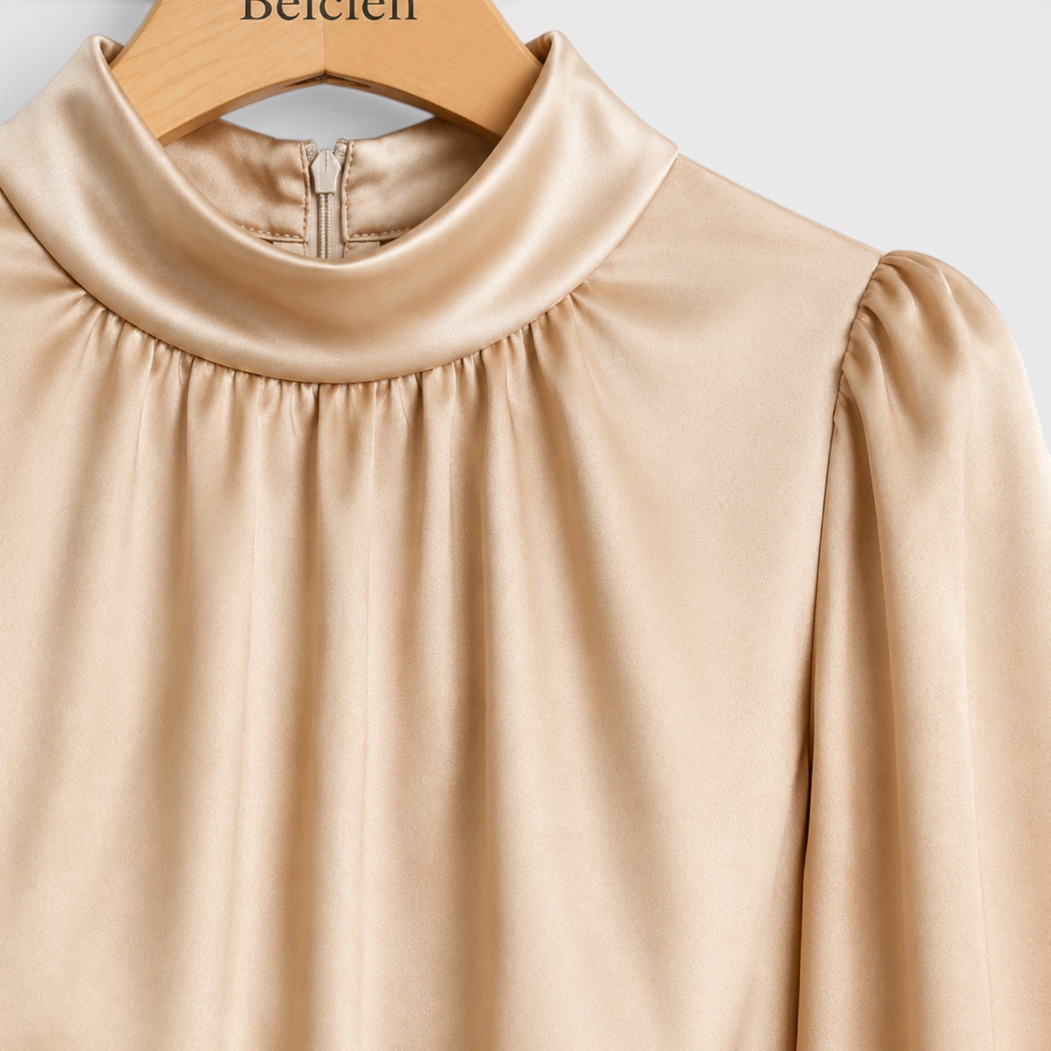Beige blouse on a hanger with 'Belcien' branding.